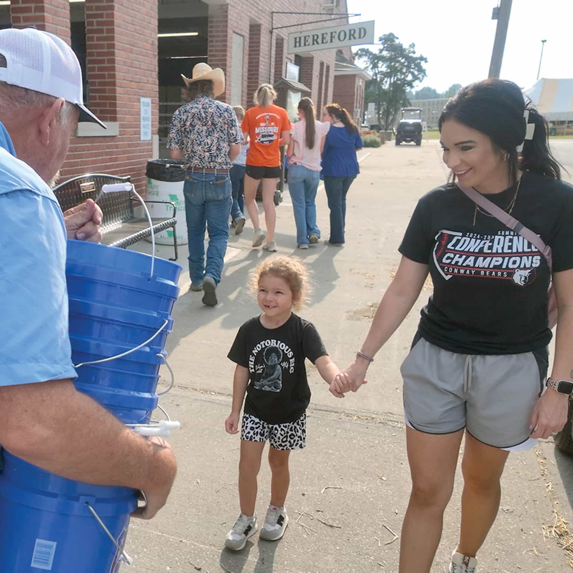 Greg Davis, left, MFA nutrition product specialist, hands out buckets filled with snacks and promotional items to youth livestock show participants at the 2025 Missouri State Fair. This popular giveaway will once again be among MFA’s activities at this year’s event, with several distribution days planned.