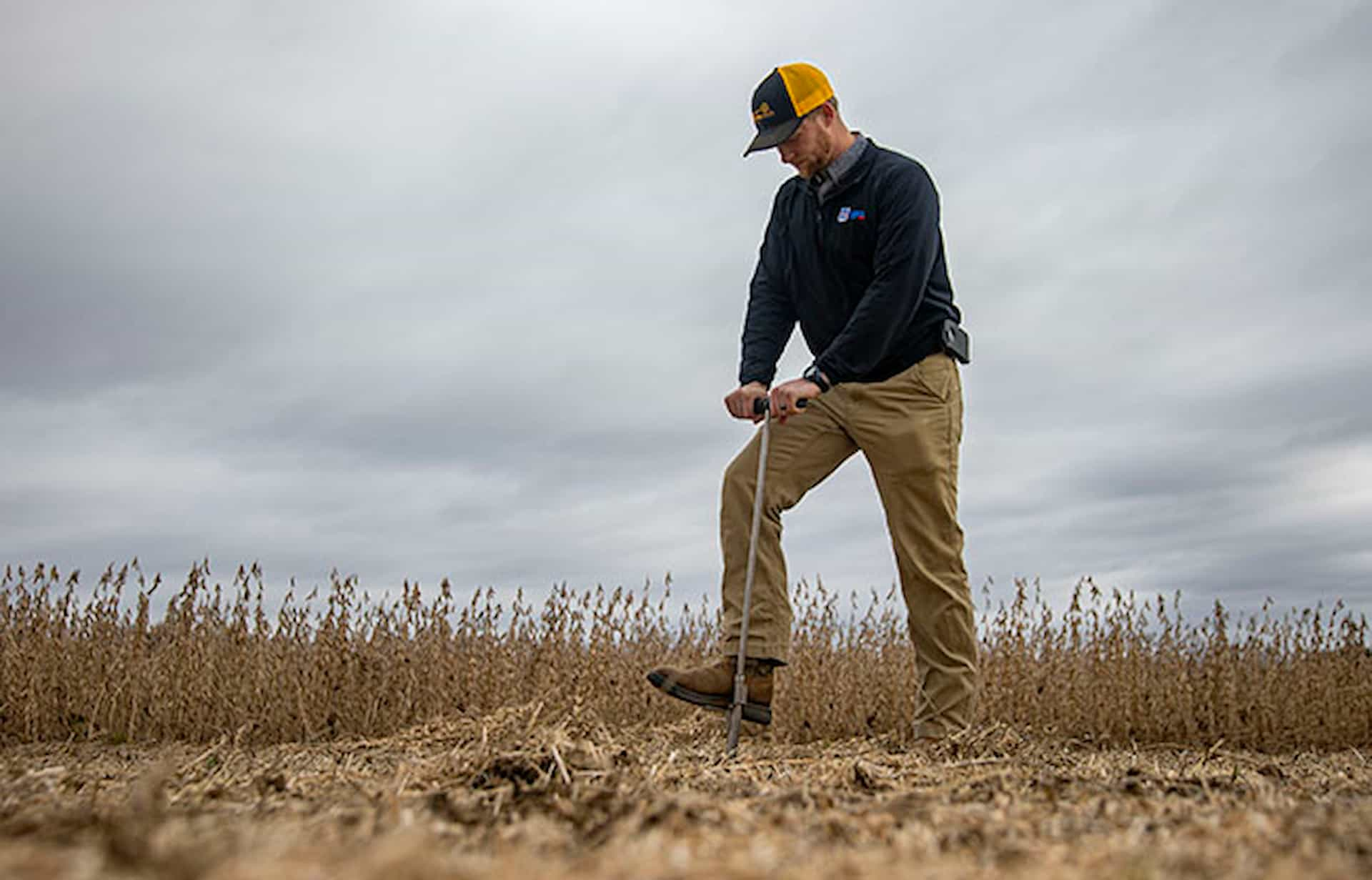 man using farm tool in field